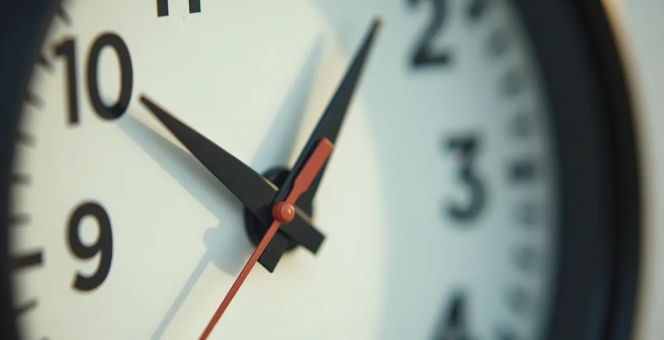 Photo minimaliste d'une horloge murale moderne, cadrage serré sur les aiguilles indiquant un moment précis